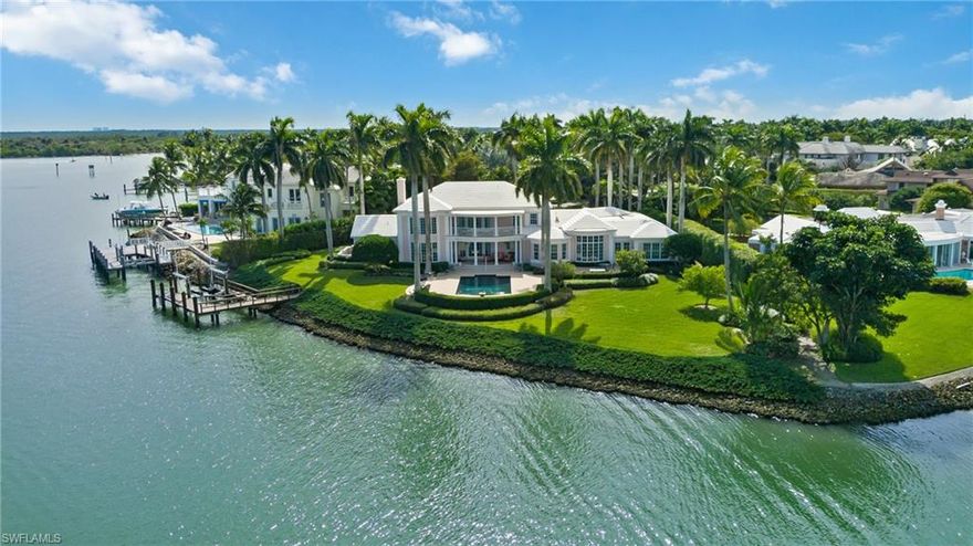 Sweeping panoramic views of Naples Bay with over 250 feet of waterfront present a yachtsman's dream in this rarely available opportunity to own one of the most desirable Port Royal properties on the highly coveted Nelson's Walk.  The private enclave known as Dolphin Cove is nestled at the end of a Banyan Tree-lined cul-de-sac offering ultimate privacy.  Deep and wide water Gulf access plus a dock with lift have all the accouterments of yacht life.  The two-story BCB built Bermuda Classic residence features 4 en-suite bedrooms, den, half-bath, formal living and dining rooms, breakfast room, den, study, and additional upstairs flex room.  A large balcony upstairs overlooks the pool and stunningly showcases the waterfront views.  Port Royal is an exclusive, sought-after community conveniently located within walking distance to Naples' white sand beaches and just minutes from 3rd Street South's and 5th Avenue South's fine dining and world-class shopping and entertainment. Owners are eligible to join the Port Royal Club, where members enjoy a fine club experience and access to a private beachfront, dining, fitness, swimming pool, and tennis facilities