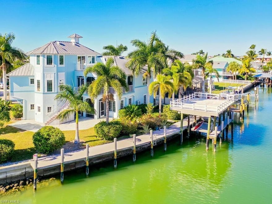 PRICED TO SELL! A Yachters Dream in Paradise is waiting for you in the Plantation Style Bayfront home on the Beautiful Isles of Capri in Naples Florida. There is 120' of DIRECT ACCESS deep waterfront with an 80' low maintenance dock that is partially covered with a large observation deck and an 8000' boat lift. This totally custom home features TWO large master bedrooms overlooking the Bay and the Rookery Bay Preserve, custom solid wood cabinets throughout, and high-end appliances. There is a luxurious living area on the second floor accessed via private elevator, with a large great room, dining room, Main Master Bedroom and guest room. The third floor features a Second Master Bedroom and bath with a loft den. Enjoy three (3) large lanais to capture sunrises and a balcony for sunsets. One of a kind property with over sized garages to accommodate 3+ cars and large air-conditioned storage. This is a unique and spectacular masterpiece, offering a blend of luxury, functionality, and the natural beauty of the Florida waterfront lifestyle. Truly, a boater's and car collector's dream in paradise awaits.
