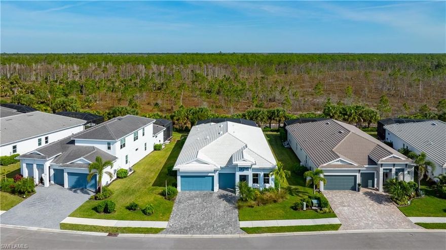 Welcome to 8999 Redonda Drive, an exquisite luxury residence that captures the sophistication and serenity of elevated Naples living. This impeccably crafted home blends architectural elegance with modern convenience, offering a refined sanctuary designed for both relaxation and grand entertaining. A stately foyer welcomes you into a sweeping open-concept great room adorned with soaring tray ceilings, custom millwork, and expansive picture windows that frame tranquil pool views. The home’s heart and soul, its chef-inspired kitchen features top-tier stainless-steel appliances, a gas cooktop and electric oven, a generous center island with bull nose edge stone, soft-close cabinetry, and a walk-in pantry designed for the culinary connoisseur. The adjacent dining spaces create a natural flow, perfect for intimate evenings or hosting with effortless style. The luxurious primary suite is a private retreat, offering forest preserve view, a spa-caliber bathroom with dual vanities, an oversized walk-in shower, and boutique-style custom closets. Additional guest suites are thoughtfully positioned for privacy, with Jack- and Jill baths, ensuring the comfort of family and visitors. Indoor living extends seamlessly outdoors through sliders that open to an expansive lanai. This resort-inspired space boasts a sparkling saltwater pool, a gas grill and multiple lounging and dining areas. Whether enjoying reflections over the pool or hosting sunset gatherings, the outdoor experience is truly exceptional. Additional enhancements include a oversized 3-car garage with storage systems, upgraded flooring throughout, designer lighting, impact-resistant windows and doors, smart-home integrations, and lush tropical landscaping that enhances both beauty and privacy. Situated in one of Naples’ premier gated communities, with tennis courts, a clubhouse, community pool and pickleball courts- residents enjoy access to exclusive amenities, world-class golf, fine dining, boutique shopping, and the pristine Gulf just minutes away. At 8999 Redonda Drive, every detail has been carefully curated to deliver a lifestyle defined by luxury, comfort, and timeless sophistication.