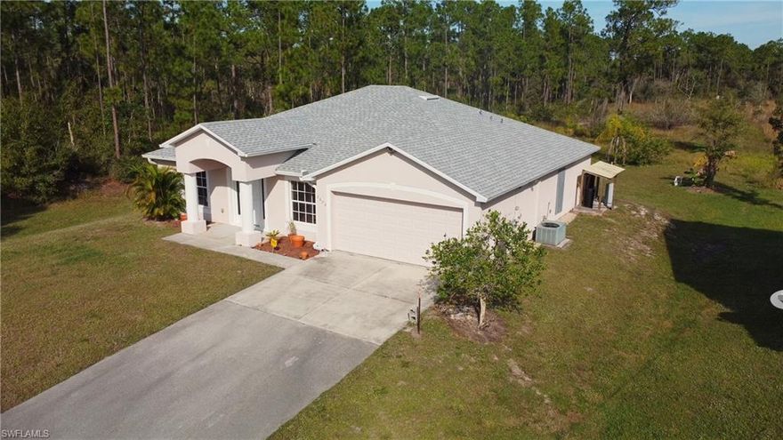 Discover this truly move-in-ready Golden Gate Estates home, where nearly every improvement has been completed in recent years. Set on 1.14 acres of cleared land, the property offers a peaceful country setting with no HOA, while remaining conveniently located just 5 minutes from shopping, parks, and nature trails.

The residence has undergone extensive recent upgrades, delivering modern comfort, efficiency, and peace of mind. Major improvements include a 2023 energy-efficient roof and tankless on-demand water heater, a 2022 asphalt driveway, and a 2021–2022 upgraded water system with softener and under-sink reverse osmosis. Inside, a comprehensive 2024 remodel introduced luxury waterproof vinyl flooring, fresh interior paint, modern smoke alarms, and updated outlets and switches throughout—giving the home the look and feel of a newly renovated property.

The kitchen is a standout, featuring new soft-close cabinetry (still wrapped), granite countertops with a seating area, a Blanco sink with multifunction faucet, pop-up power and USB charging station, oversized refrigerator, Wi-Fi-enabled LG microwave, and a brand-new oven and range to be installed prior to closing. The guest bathroom was fully redesigned in 2024 and has never been used, offering a European vanity, artistic glass sink, dual showerheads, metallic tile, and modern fixtures.

The primary suite includes a walk-in closet, double sinks, a separate shower, and a soaking tub. Guest bedrooms and the laundry room were refreshed in 2025 with new flooring, paint, lighting, and outlets. Two separate living areas provide flexibility for a den, office, or an easy conversion to a fourth bedroom without sacrificing living space.

Additional features include an oversized garage with RV and generator hook-ups, storm shutters, motion-sensor exterior lighting, and Ring camera connectivity. The property currently borders 10 untouched acres, enhancing privacy, and offers ample space to add a pool, create outdoor living areas, or accommodate horses. This home seamlessly combines tranquility, recent high-quality upgrades, and modern convenience.