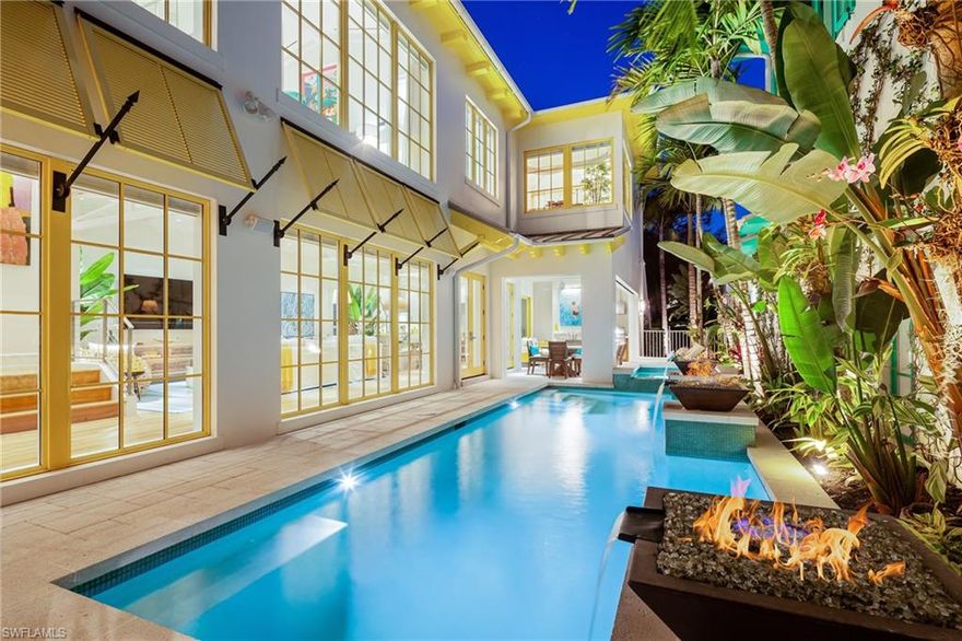 Welcome to Bananaquit! This stunning Olde Naples home offers a luxurious, private courtyard setting in a highly sought after location, near beaches and the bay. The unique design features 4 bedroom suites with private baths, a private cabana, and a 2-car garage. The first floor hosts a fantastic open concept great room and kitchen, one of the bedroom suites, plus a covered lanai with a summer kitchen and outdoor fireplace. Floor-to-ceiling windows throughout the main living areas showcase the stunning pool courtyard, and a wall of glass in the kitchen opens seamlessly to the lanai. Upstairs is the master suite and 2 additional guest suites, one of which is a guest cabana with its own entrance. The interior is finished with Legno Bastone European wide plank floors, quartz and marble counters, Miele appliances, and custom cabinetry. Impact glass windows and doors, home automation, including surveillance, sound, and lighting are some additional upgrades. The exceptional like-new residence also has an enviable location walking distance to Crayton Cove and Cambier Park and near beaches, and renowned shopping and dining at 5th Ave S and 3rd St S.