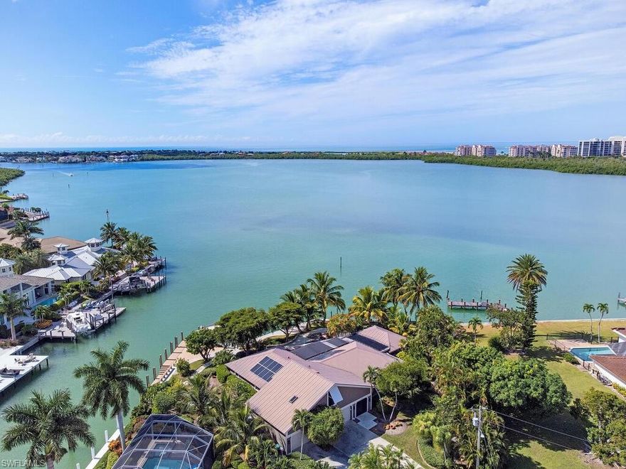 206' of water frontage, only minutes to the gulf. A 64' and a 23' dock will accommodate a 70' or larger yacht, plus 2 boat lifts. Incredible outdoor living awaits you at this 3 bedroom, 3.2 bath resort style residence. Natures abounds with all breeds of sea birds, song birds, manatees and dolphins. The sun sets across the wide spans of Collier Bay, creating multi colored skies for early evening viewing. The outdoor bar is surrounded by coconut palms and other native plants while the black bottom pool reminds you of a tropical pond. The charming interior features master suite and guest suite down while the second master suite is on the second level. A cooks kitchen, gorgeous dining room, living room with game table and powder bath complete the ground floor living. This is a truly one-of -a kind property that will afford much enjoyment to a new owner.