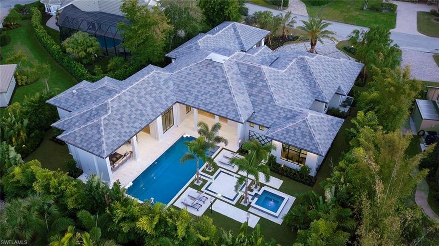 Tropical Resort Living Reimagined! Stunning 2019 Rustic Contemporary Estate in the heart of Pelican Bay lives like a private resort. Extraordinary curb appeal with architecturally inspired stone and wood exterior perfectly complimented by lush mature tropical landscaping. A contemporary yet casual coastal interior vibe flows throughout. Floor to ceiling windows, gorgeous custom cabinetry, chic designer furnishings... AND THAT POOL!! Two spacious outdoor living areas overlook a 50’ resort style pool, 8’ infinity spa, and gaslight tiki torches that light at the touch of a button… all nestled in a completely private backyard. This is a true resort style home, featuring the most amazing outdoor living space of the season. Over 4,600 sf under air, 4 en-suite bedrooms, 3 living areas, a Chef’s kitchen with top-of-the-line appliances, and much more. Situated on a 1/2 acre just moments from Waterside, Artis-Naples, Mercato, and a short walk to the beach. Pelican Bay offers 3 miles of sandy beach, 2 gulf front beach clubs with dining and beach service; competitive tennis and the brand-new Club Pelican Bay featuring 3 award winning restaurants, 27 holes of golf, fitness center and spa.