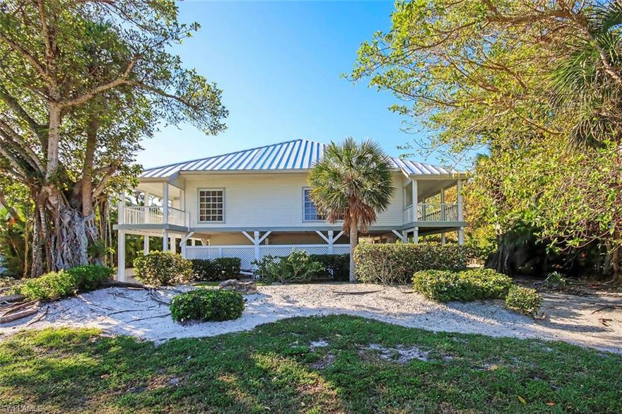 Imagine living in a tropical forest tree house! This elevated beach home boasts decking from every room. Open the pocket sliders, breathe in the warm, balmy breezes and feel yourself relax. Every room is filled with light! The living area features a vaulted ceiling and the efficient kitchen has newer stainless-steel appliances, a dumb waiter, and an island/breakfast bar. Uniform tile plank flooring throughout and serene wall colors enhance the island decor. The large primary bedroom features room for a cozy sitting area and two walk-in closets. The first guest room, located on the main living level, has a private lanai and the second guest room is on the top floor with a bath and private deck. Enjoy a sparkling, heated oversized pool with a spacious deck for sunning or relax while lounging under a covered area by the pool. Backing up to a nature preserve, this home offers wonderful privacy.  All decking is protected by a Pynamite misting system. The laundry is conveniently located on the main living level by the bedrooms and there is an abundance of storage in the floored attic, attached garage, or outside under the decking. This home is cooled and heated by a mini-split system for customized, individual comfort in every room. The owners flood insurance policy is assumable. Located in the popular Dunes subdivision, you can enjoy all the activities that the Dunes Golf and Tennis Club offers with an affordable membership or with the "pay as you play" option. On/off access to the island is so easy from the Dunes. Come see this home today and start living the island lifestyle that you have been dreaming about.
