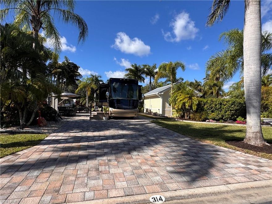 Lot 314, completed with exquisite pavers in 2024, exudes sophisticated curb appeal from every angle. Impeccably landscaped with lush tropical plants, this property is designed for those who love to spend time outdoors in style. Enjoy a serene shaded seating area at the front, perfect for relaxing mornings, or soak up the sun on the back lanai, complete with ample space for lounging and gourmet outdoor cooking. The coach house is meticulously maintained and immediately welcoming. Inside, you’ll find a well-appointed kitchenette with a high-end refrigerator and small dishwasher, a bathroom with a shower, a functional gourmet food prep area, and space for a chic mini bar or elegant coffee nook. Thoughtful touches include custom storage bins to keep outdoor gear organized, pavers surrounding the charming coach house, a large stylish awning, and pristine glass doors with privacy blinds. At the back, the property borders a peaceful common area, perfect for fur babies to roam freely. Location-wise, it’s unbeatable: a short stroll brings you to the luxurious River Clubhouse, resort-style pool, pickleball courts, and dog park. Beyond your private haven lies the full RiverBend experience. The Caloosahatchee River flows serenely along the resort, ideal for morning walks, sunset views, and watching boats drift by. RiverBend offers expansive, first-class amenities, from the sparkling pool with loungers and shaded umbrellas to bubbling hot tubs. The River Clubhouse provides a vibrant social scene with live music, trivia nights, holiday parties, themed dinners, and spaces for billiards, reading, and relaxation. Stay active with pickleball, bocce, Zumba, line dancing, or join one of the many clubs, from the Creations Guild to remote control boating and racing. Even your pets enjoy their own well-appointed space at the meticulously maintained dog park. When cooking isn’t on the agenda, the resort often serves delightful refreshments, breakfast, and dinner at the clubhouse. This exceptional lot perfectly blends beauty, convenience, and sophisticated luxury Class A motorcoach living, the ultimate RiverBend lifestyle. Outdoor furniture is negotiable for the discerning buyer.