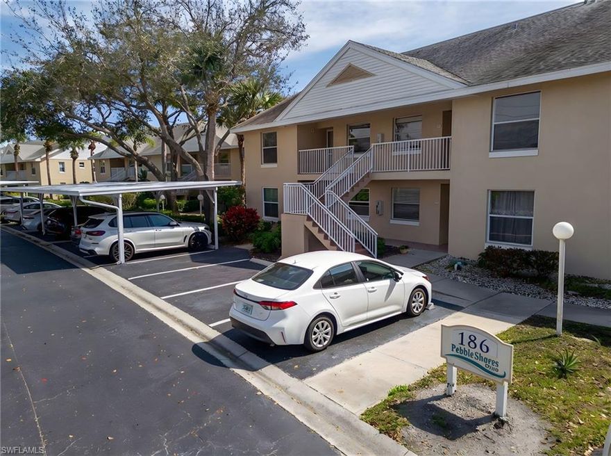 The "Heron" floor plan of this second-floor condo secures a magnificent, long lake view encompassing an active water display directly from the main living area and the master bedroom. At 1,225 square feet of under-air living space, this coveted, bright and airy end-unit represents the largest footprint available within the complex. The modern layout provides two split bedrooms, two full bathrooms, and a dedicated den which can be easily converted into a third bedroom. Interior architecture is defined by volume ceilings and an expansive 14'0" x 23'0" grand room, which utilizes sliding glass doors to transition seamlessly to the screened balcony. The kitchen is equipped with stainless steel appliances and a functional pass-through serving bar. It flows into a cozy nook perfect for eating, relaxing or reading. The master bedroom boasts a spacious walk-in closet and an ensuite bathroom. The asset is offered turnkey, presenting an immediate, fully equipped acquisition for the next owner. Located in the highly sought-after Palm River corridor of North Naples, Pebble Shores is a low-density, pet-friendly enclave offering exceptional structural integrity and strictly optimized carrying costs. Constructed with solid concrete block and underground utilities to secure favorable insurance premiums, the community features a highly efficient HOA that bundles fiber-optic internet, cable, water, and exterior maintenance to protect your bottom line. Residents enjoy a resort-style heated lakeside pool, spa, clubhouse, and scenic walking paths surrounded by mature tropical landscaping. Parking is a breeze with one assigned carport parking and one open-space parking for each unit. Geographically positioned for maximum lifestyle utility and sustained asset appreciation, the property sits just three miles from the Gulf waters of Delnor-Wiggins Pass State Park and minutes from Mercato and Seed to Table. With optional memberships available at the adjacent LaPlaya Beach & Golf Club, Pebble Shores delivers prime North Naples geography without the heavy burden of CDD or mandatory club fees.