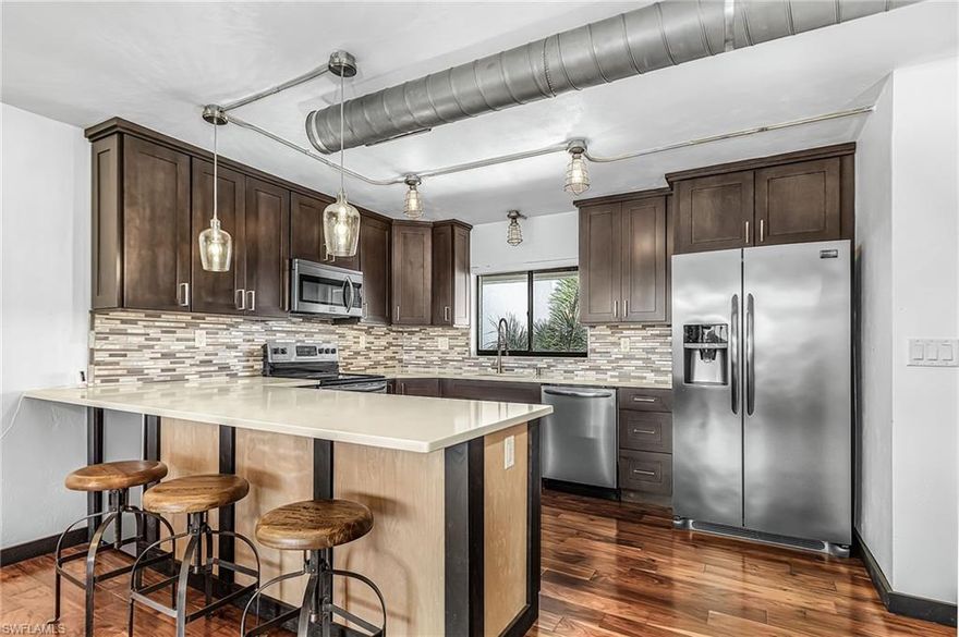 This contemporary top-floor three-bedroom turnkey condominium offers a downtown loft ambiance with a unique industrial appeal. The open concept features elevated ceilings, beautiful 42-inch wood cabinetry, stainless appliances, quartz countertops, retro pendant lighting and stylish glass tile backsplash.   Gorgeous wood flooring, designer solid core doors and trim enhance the interior. Fully renovated baths feature new vanities, seamless shower doors, and modern tile; the guest bath includes a Jacuzzi tub. Sliding barn doors from the living room provide versatility for the third bedroom or den/sitting area. Comfy leather seating.  The lanai offers exceptional golf and lake views, providing a relaxing atmosphere, and a roll-down storm screen provides protection from wind and rain.   Trawler Village is centrally located within The Landings Yacht, Golf & Tennis Club, where you’ll enjoy the active and “bundled” lifestyle that includes golf, tennis, pickle ball, bocce, fitness center, lap pool and a boat slip in the well protected Gulf-access marina. Two dining clubs, waterfront picnic area and endless activities. Come live the good life!