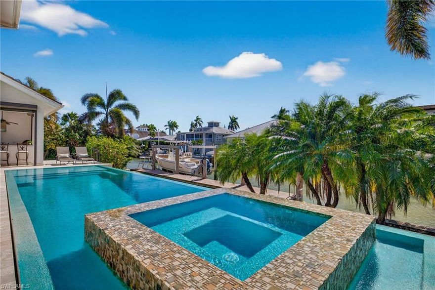 Built in 2016!Perfectly positioned in Royal Harbor, this impressive waterfront home delivers the boating lifestyle Naples is famous for—at an outstanding value. Located on a deep-water canal less than 100 yards from Naples Bay, 1330 Marlin Drive offers quick, effortless access to open water, with the Gulf of Mexico reachable in a mere 12 minutes. It’s easy to see why Royal Harbor remains one of Naples’ most sought-after boating communities.

Designed for both everyday comfort and elevated entertaining, the residence offers an expansive layout with approximately 4,300 square feet under air plus an additional 1,000 square feet under roof. The home features four private en-suite bedrooms, a powder room and dedicated pool bath, a large home office, and a second-floor bonus family room that creates excellent separation and flexibility for guests.

Inside, refined finishes include marble and hardwood flooring along with beautifully crafted living spaces that flow seamlessly to the outdoors. The kitchen serves as the center of the home, opening to a spacious family room across a generous breakfast bar—ideal for gathering. Pocketing sliders invite you outside to a true resort-style setting with an outdoor kitchen and bar, indoor and outdoor gas fireplaces, and a stunning infinity-edge pool, all perfectly oriented for coveted southern exposure.

The primary suite is located on the first level, offering a luxurious bath and dual closets, while another first-floor bedroom provides an ideal guest retreat. Upstairs, two additional en-suite bedrooms are complemented by a secondary living area complete with a wet bar and refrigerator, and an upstairs balcony provides beautiful views toward Naples Bay.

Outdoors, the property continues to impress with a private dock featuring a 16,000 lb boat lift and fish cleaning station—everything you need for effortless waterfront living. The tandem three-car garage offers exceptional storage and space for a golf cart, motorcycle, or additional vehicle. Additional thoughtful details include an elevator shaft already incorporated into the design for future use. There are fruit-bearing trees throughout the side yards including mango, papaya, lime, starfruit, and banana.

Built by the home’s original owners—residential and commercial builders—this property reflects exceptional craftsmanship, quality, and attention to detail at every turn, such as concrete block throughout all floors and a rebar reinforced pool. No flood or hurricante damage! All of this is just minutes from downtown Naples, fine dining, world-class shopping, entertainment, and the area’s renowned white-sand beaches.  Easy access to I-75 and Naples and Fort Myers airports.