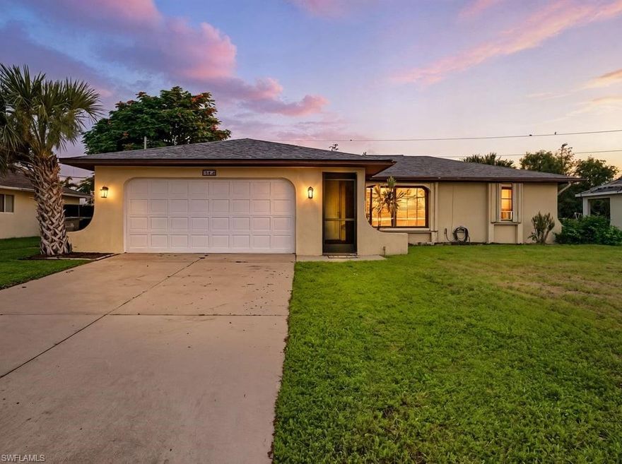 This charming home offers three bedrooms, two bathrooms, and a two-car garage, located in southeast Cape Coral. The property is connected to city water and sewer, and all assessments have been paid. Tile flooring is featured throughout the main living areas, offering both durability and easy maintenance, while the bedrooms are fitted with new carpeting for added comfort. Adjacent to the dining area is a rear bonus room, which provides extra space and direct access to a covered, screened-in lanai, perfect for relaxation or entertaining guests. The large, fenced backyard delivers ample room for outdoor activities and features a mango tree and banana trees, adding a touch of tropical charm. Notable updates include a new roof installed in 2023 and a new HVAC system from 2019, contributing to the home's overall value and comfort. The kitchen features newer stainless-steel appliances, all less than one year old, enhancing both style and functionality. The house also comes with accordion hurricane shutters and metal shutters for the doors, offering added protection and peace of mind during storm season. This property offers an ideal location, conveniently situated near restaurants, shopping centers, grocery stores, and schools, with easy access for commuting to various destinations.