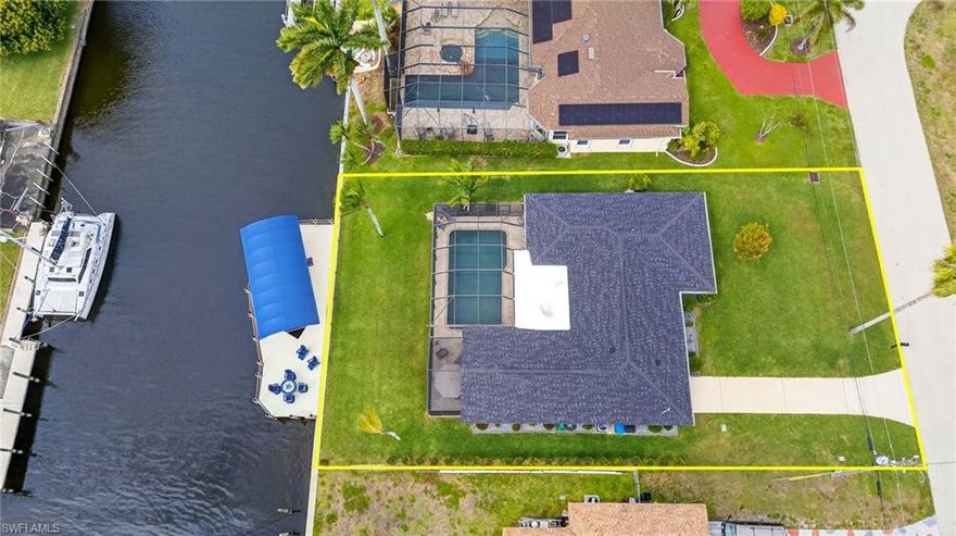IMPRESSIVE home and location! Gulf Access waterfront residence ideally positioned on a wide canal with quick, direct access to the open water! Now with a generous reduction in price! Thoughtfully enhanced the owners have over $148,00 in additional upgrades and spared no expense! This home showcases a newer composite dock with 13,000 lb boat lift (accomodating up to a 34' vessel) along with water, electric, canopy,  and ambient dock lighting. A spacious waterside seating area (20x25) invites you to relax and enjoy the tranquil canal views, complimented by a newer seawall. This 4 bedroom, 3 full-bath pool home boasts 2 master suites and a bright open-concept design. The beautifully updated kitchen features quartz countertops wiith waterfall edge on the large island, tile backsplash white cabinetry and premium appliances including a gas range. The living/dining areas feature newer impact glass doors that open to the screened paver stone lanai area with saltwater pool (w/ overhead lighting) creating seamless indoor-outdoor living views. There is a newer underground propane tank which also heats the on-demand hot water tank.  There's so much more: ProVia hurricane windows with solar max technology and lifetime warranty, ProVia hurricane front door (lifetime warranty). The 1st master bedroom suite also offers access to the addition of a newly screened in Lanai (5/2023).  New mini split AC system cools the garage/office space. All lighting inside was replaced to reflect a modern day style. New Rain Bird irrigation system with app remote control. Pool has new heater, filter system (saltwater) and pump. Home and dock has complete Security System with Cameras.  There's so much more a list is provided with updates and costs. This home had NO flooding from storms & will surely impress the most pickiest buyers! Also of note: all piping under slab & all electric had been replaced to make this home better than new. This home has great potential as a rental or investment property.