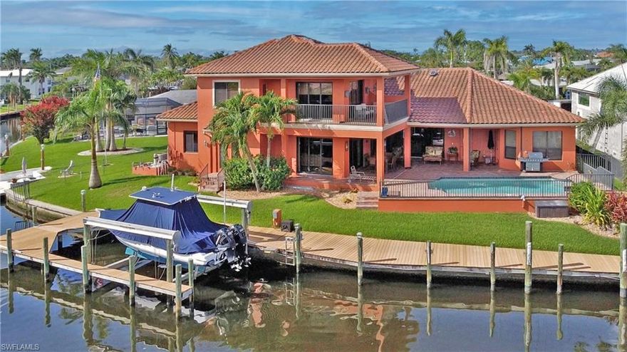 Exquisite and spacious Arthur Rutenberg direct Gulf-access pool home with sweeping views of Bimini Basin in Cape Coral's 'Yacht Club' neighborhood. This award-winning St Tropez III floor plan is customized to take full advantage of the gorgeous water views, which extend out 900+ feet across the Bimini Basin. The huge 3738 square foot home features 3 bedrooms, 3.5 bathrooms, 8 car garage, formal dining room, office, second floor den/exercise/family room with wet bar, second floor terrace. Master suite on first floor. Gas stove top. Three AC units. Beautiful appointments through-out including crown molding, high coffered ceilings and doorways. Huge garage with 1321 square feet and two car lifts to fit 8 cars. Solar heated inground pool. Solid construction: second story is also concrete block, tile roof, and impact windows and doors, home had zero water intrusion from Ian. The house sits on the corner of the Basin and Tarpon Canal with 154 feet of waterfront on almost a 1/3 acre. Large composite boat dock with a captain's walk and a 27,000 lb lift. By boat, the river is a straight ride down the Bimini Canal, no bridges. The Basin always has boat activity to watch, and provides a front row seat to the City's annual Holiday Boat along. On a dead end street, you'll see more boat's in the back yard than cars passing in the front. Short distance to the Yacht Club, restaurants, retail, and the exciting redevelopment of downtown Cape Coral. There's a waterfront restaurant being completed across the basin--a Floor plan available.