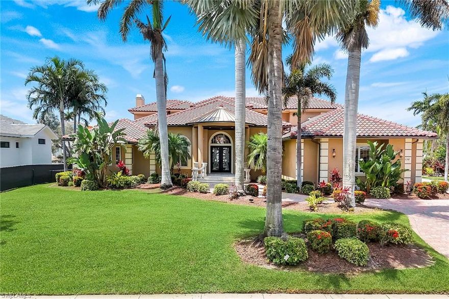 An exceptional offering in Marco Island's prestigious Estate section, this canal-front residence encompasses over 6.000 square feet of living space on an oversized 125-by-175-foot homesite. Designed for the discerning waterfront buyer, the property boasts two boat lifts—one 35,000 pounds for a 40-foot vessel— and a 20,000 pounds, adding an extra level of boating enjoyment, direct Gulf access and a dedicated fish cleaning station. The interiors blend architectural grandeur with livability. Expansive windows and high-impact doors throughout the home invite natural light and frame water views while providing enhanced security and storm resilience. Every room reflects exquisite attention to detail—from soaring ceilings, breathtaking cupola, and fine finishes to refined millwork and custom built-ins. The primary suite is a private sanctuary, offering a sitting room, wet bar, spa-inspired bath and a dedicated fitness room. Upstairs, a second guest suite features a loft and a private lanai with panoramic views of the water and city skyline. Formal living and dining rooms are paired with a great room featuring a fireplace and bar, while the chef's kitchen—equipped with a gas range and walk-in pantry—delivers efficiency and function. A private theater/media room, complete with wet bar, fireplace and guest bath, provides a luxe space for entertaining. Outdoor amenities rival private resorts, including a pool, spa, pool bath, fireplace, full summer kitchen and a bonus rooftop capturing sweeping vistas. Additional appointments include a top-notch Sonos surround sound system, Savant home automation, a 30,000-watt generator with 1,000-gallon propane tank and a three-car garage. A new tile roof was completed in 2025 and the seawall dates to 2003. This residence offers a rare combination of coastal access, architectural integrity and elevated design in one of Marco Island's exclusive enclaves.  Adjacent lot set up as tropical beach site also for sale separately. Paradise living at its finest.