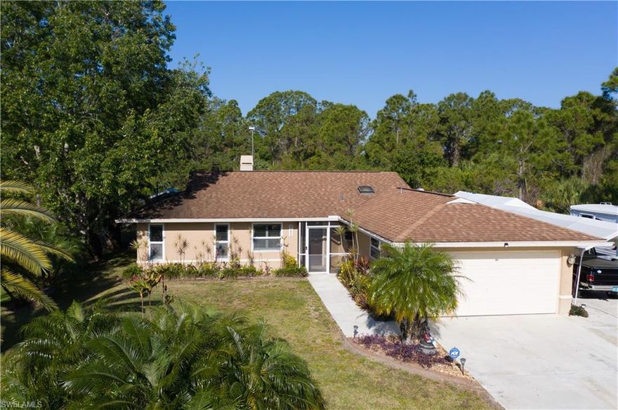 What a serene setting this fabulous home offers with lush landscaping, extra parking pad, extra lot next door included in sale and fenced backyard. This 3 bedroom, 2 bath, family/den room home has tile throughout, large lanai across entire rear of home = perfect for outdoor living without the bugs. Did I mention 1/2 the lanai resembles a tropical oasis with a lovely water fountain and the 1/2 is covered for shade. The interior: windows have Plantation shutters, central vacuum, surround sound, fireplace with wood/gas, pull outs on the kitchen cabinets. The exterior: doggie door, Rain Bird sprinkler system, gutters, shed, manual shutters, 110/50/30 amp plug in for an RV, RV parking, and so much more. Minutes to shopping, marina, restaurants, and airports. Out of special flood zone, per map*