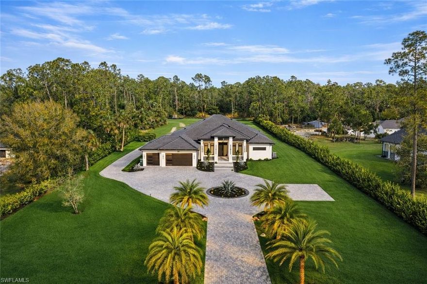 A statement of architectural excellence and modern luxury, 467 20th Ave NE is a newly completed 2024 estate that redefines refined living in Naples—where cutting-edge design, master craftsmanship, and resort-style amenities converge on an expansive private setting.

Located within the coveted acreage lifestyle of Golden Gate Estates, this impeccably designed residence offers 4 bedrooms, a private den, and 4 full bathrooms across approximately 3,300 square feet of living space, all thoughtfully curated to deliver both grandeur and livability. From the moment you arrive, the circular paver driveway, dramatic landscape lighting, and elegant architectural lines set the tone for what lies within.

Inside, soaring 13-foot ceilings, Level 5 drywall finishes, and a striking electric fireplace anchor the great room, while full-wall pocket sliding doors dissolve the boundary between indoors and out—framing breathtaking views of the expansive backyard and creating a seamless flow for entertaining. Throughout the home, an extraordinary 28 full slabs of quartz, quartzite, and porcelain elevate every surface with timeless sophistication.

The chef’s kitchen is nothing short of spectacular, featuring JennAir panel-ready appliances, custom white oak cabinetry, an architectural “floating” ceiling, and an oversized island designed to impress. A fully equipped butler’s pantry with a second refrigerator and wine fridge adds both functionality and elegance, making hosting effortless and elevated.

The primary suite is a true sanctuary, complete with dual walk-in closets and a spa-inspired bath showcasing a walk-around shower with multiple shower heads and bench seating, dual vanities with abundant storage, and a Toto toilet—all designed for daily indulgence. Just off the suite, a private office with French doors offers a refined work-from-home retreat. A split-bedroom floor plan provides exceptional privacy, with two additional guest suites each featuring their own attached full bathrooms.

Designed for next-level indoor-outdoor living, the expansive covered lanai is outfitted with a full outdoor kitchen and bar, electric fireplace, Sonos audio, and automatic roll-down screens—creating an all-season entertaining destination. Beyond the lanai, over 2,600 square feet of paved decking surrounds a manicured backyard highlighted by a private soccer field with sprinkler-fed Zoysia grass, offering endless flexibility for recreation or relaxation.

Additional premium features include impact-rated windows and doors, a three-car garage with epoxy floors, dual wells (one dedicated to irrigation), a 500-gallon reverse osmosis system, soffit-mounted holiday outlets, palm-tree lighting outlets, motion-sensor illuminated shell stone entry steps, and pre-wiring for a future front gate. Situated on 100% upland land with no flood insurance required, this property delivers peace of mind along with privacy and prestige.