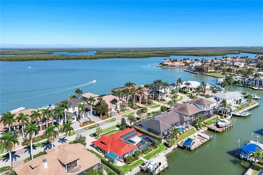 Perfectly positioned along the Marco River with 100 feet of waterfront and coveted southwest rear exposure, this exceptional boating property offers direct Gulf access just moments from the island's central cut-through--cruise west to Isles of Capri Pass or east to Coon Key Pass within minutes. A new dock and seawall (2025) with rip rap and green light create an ideal setting for Snook fishing and waterfront enjoyment. Beautifully remodeled and meticulously improved over time, the home has been opened to create generously scaled interiors centered around a large island kitchen that flows naturally into the main living spaces. Four pocketing sliders open the living and dining areas to a beautifully redesigned pool with in-ground spa and expansive screened lanai overlooking the water--perfect for enjoying Marco Island's year-round sunshine. A family room bay window frames tranquil canal views. One of the guest bedrooms connects by hallway to a charming sunroom with privacy shades and sits conveniently across from the pool bath, creating an ideal arrangement for guests to enjoy relaxed indoor-outdoor living. Features include a durable 50-year metal barrel-tile-style roof, impact windows and doors, remodeled kitchen and designer baths, updated driveway and garage floor, and recently refreshed landscaping along with mature plantings and palms. Solar panels provide exceptional efficiency with low monthly electric costs, complemented by a 10-kW generator with electrical panel, capable of powering most of the home. Situated just off North Barfield Drive near the Shoppes of Marco, the location offers convenient access to the beach, island dining, and shopping, with an easy route on and off the island. Offered partially furnished and reflecting an unmistakable pride of ownership, this exceptional residence invites you to step directly into the boating lifestyle Marco Island is known for--in a remarkable home beautifully positioned along the Marco River.