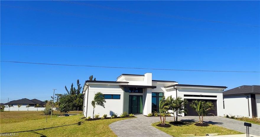 Stunning newer contemporary waterfront home - built in 2024! This exquisite 3-bedroom, 3-bathroom residence, complete with a den, is a refined example of modern coastal luxury, perfectly situated along a tranquil freshwater canal in Cape Coral. Spanning 2,007 sq ft of air-conditioned space, the home is defined by its architectural elegance and sophisticated design, featuring a striking 12-foot ceiling and a custom designer feature wall that anchors the main living are. At the heart of the home, a sleek European-style kitchen showcases clean lines and premium finishes, featuring custom cabinetry, an island, and expansive quartz countertops—a statement space designed for both entertaining and everyday sophistication. The primary suite is a private sanctuary, offering a spa-caliber experience with dual vanities, a secluded water closet, and a frame-less glass walk-in shower, curated for comfort and tranquility. Floor-to-ceiling impact glass sliders create a seamless transition to the expansive 558 sq ft covered lanai, where indoor and outdoor living merge effortlessly against the backdrop of tranquil waterfront views. Crafted with quality and durability in mind, this home adheres to modern construction standards and incorporates energy-efficient features throughout—ensuring both luxury and peace of mind. This is a unique opportunity to own a newly constructed, design-forward waterfront residence that captures the true essence of Southwest Florida living at its best.