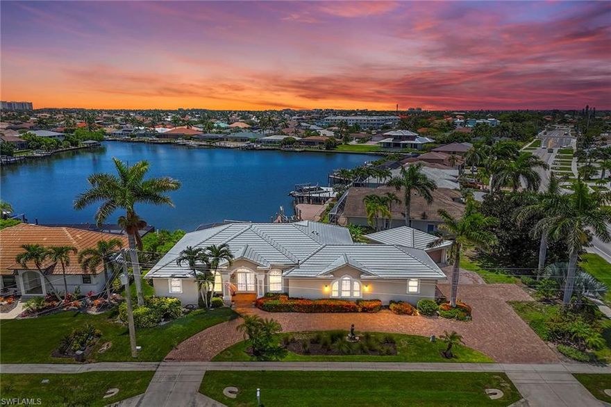 Welcome to an exceptional waterfront residence offering sweeping bay views and a seamless blend of comfort and refined living. This expansive four-bedroom, three-bath home, enhanced by a versatile den, expansive media room and with 2,716 square feet under air, sits on a generous oversized corner lot. A stately papered circular drive leads you to ample parking, including a two-car attached garage and an additional two-car detached one, offering abundant space for vehicles and storage. Upon entry through the custom-etched dolphin door, you are welcomed into a formal living area enhanced by a decorative built-in electric fireplace setting the tone for the charm that unfolds within, ideal for cozy evenings or intimate gatherings. The separate dining room is ideal for formal events, while a dedicated den/office provides built-in shelving and cabinetry for a functional workspace. The kitchen boasts gleaming granite countertops, built-in desk, an abundance of custom cabinetry, stainless steel appliances, breakfast bar, and a sunlit morning room with panoramic bay views. The adjacent wet bar, complete with a wine cooler, makes an effortless entertainment, while the family room provides a warm and welcoming space for friends and loved ones to gather. The thoughtful split-bedroom floor plan ensures privacy and convenience. The primary suite is a tranquil retreat with a luxurious en-suite bath, while a second bedroom also enjoys its own en suite. Two additional bedrooms are served by a pool bath, which can be closed off for added seclusion and is ideal for guests or family. A large, versatile media room provides endless possibilities for relaxation and recreation. Throughout the home, vinyl and tile floors complement vaulted and tray ceilings, creating an atmosphere of understated elegance. Enjoy the best outside living from the screened lanai, where you can watch dolphins play or bask in the sunshine beside the sparkling pool with a built-in barbecue and fire pit, making this ideal for alfresco dining and year-round entertainment. Waterfront amenities include a private dock and boat lift, inviting you to fully embrace the boating lifestyle. Additional highlights include electric and manual shutters for peace of mind, a new roof installed in 2020, and manicured landscaping that enhances the property's curb appeal. This residence presents a unique opportunity to enjoy extraordinary bay views and upscale waterfront living.