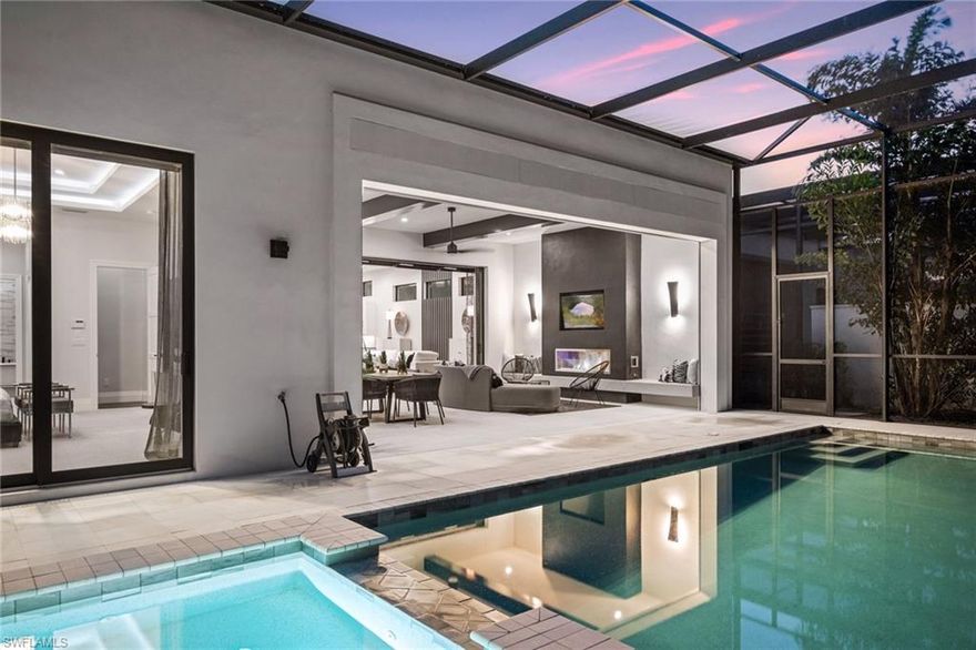 Welcome to this luxurious single-family Beach Villa crafted by Divco, nestled within the exclusive Trevi neighborhood of the renowned Miromar Lakes Beach & Golf Club. This exquisite four-bedroom, four-and-a-half-bath residence is designed with modern elegance, featuring richly contrasting tones, dark wood flooring, artisan tile accents, quartz countertops, and custom-finished vanities. The open-concept layout seamlessly integrates a spacious great room, an elegant dining area, and a chef’s kitchen equipped with premium stainless steel appliances, light cabinetry, a walk-in pantry, and a wet bar with a wine refrigerator—creating an ideal space for both casual living and grand entertaining. Step outside to your private outdoor oasis, where a resort-style pool and spa invite relaxation, while an outdoor kitchen and fireplace set the perfect ambiance for alfresco gatherings. Situated between a pristine white-sand beach and a 700-acre freshwater lake, this residence offers direct access to boating, waterskiing, and wakeboarding from a shared dock in the backyard, while the lush Botanical Park in the front yard provides a peaceful retreat. At Miromar Lakes Beach & Golf Club, residents enjoy a five-star resort lifestyle with three miles of private beach, two marinas, a Beach Clubhouse, Blue Water Beach Grill, a 10,000-square-foot zero-edge infinity pool, and courts for tennis, bocce, and pickleball. The full-service European-style Spa & Fitness Center offers ultimate relaxation, while a vibrant social calendar fosters a welcoming and dynamic community. Golf enthusiasts can also opt for membership at the Arthur Hills Signature Championship Golf Course, featuring a masterfully designed layout that challenges and inspires. Experience the ultimate lakefront lifestyle, where luxury, recreation, and relaxation are seamlessly woven into everyday life.