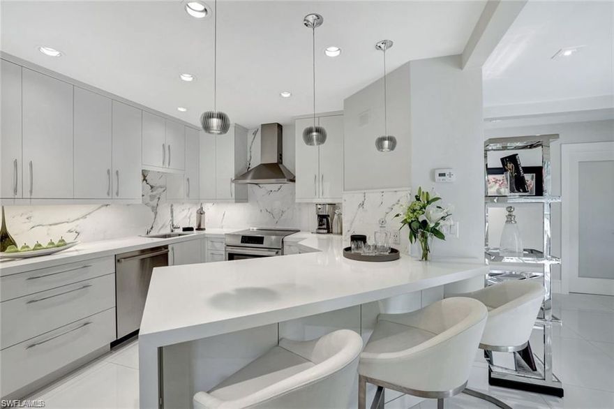 Ideally located just steps from the Gulf of Mexico, this condominium building sits in the coveted X-500 Flood Zone and has never experienced storm water intrusion.
Set in a high-and-dry location within walking distance of upscale boutiques and world-class restaurants, this artfully redesigned residence epitomizes the Old Naples lifestyle.
Meticulously transformed from its original mid-century design, the home now features a clean-lined, contemporary aesthetic. Highlights include impact-rated windows and doors, polished porcelain flooring throughout, floating bathroom vanities, 1¾” solid core interior doors, and two fully outfitted walk-in closets.
Thoughtful, unexpected touches include a double glass-door entry to the primary suite, a striking 60-inch white glass fireplace, and a chef’s kitchen with custom cabinetry, mitered quartz countertops, and full Calacatta Extra marble slab backsplashes featuring dramatic, organic veining.
Top-tier appliances complete the kitchen: a Liebherr refrigerator, 23-bottle under-counter wine cooler, Bosch induction range, microwave drawer, and Bosch washer, dryer, and dishwasher.
A seamless transition from the main living area leads to the screened outdoor lanai, perched above the property’s stone waterfall and private landscaped courtyard—perfect for year-round enjoyment.
Truly a contemporary masterpiece for the most discerning buyer