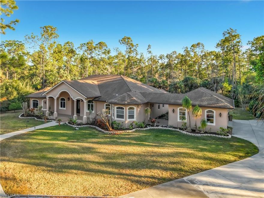 CUSTOM ESTATE ON 2.73 ACRES – BEST VALUE IN COLLIER WOODS

Welcome to your private sanctuary.

Situated on a sprawling fully fenced and gated 2.73-acre lot, this extraordinary custom-built home offers a level of craftsmanship and architectural detail rarely found at this price point. A grand circular driveway and stately arched portico welcome you into an expansive interior defined by soaring volume ceilings with double backlit tray details and distinguished arched windows that flood the home with natural light.

The heart of the home is a generous chef’s kitchen featuring abundant rich custom cabinetry, expansive granite countertops, double wall Wolf ovens, a massive center island and an oversized finished walk-in pantry. The split floor plan ensures ultimate privacy for the primary suite, which boasts bamboo wood flooring, a sitting area, and a spa-inspired bath with a soaking jetted tub and oversized walk-in shower. The water closet connects to a smaller room which is perfect for a nursery, office or library.

Efficiency is paramount, featuring two top-tier heat pumps (4 & 2-ton), an 80-gallon hybrid water heater, and a whole-house RO system with a 500-gallon tank. The oversized 3-car garage (separate 2-car and 1-car bays) is equipped with two Tesla EV wall chargers, while the pool utilizes premium variable-speed equipment.

Step outside to your own tropical resort: the massive screened lanai houses a solar-heated, salt water free-form pool with a custom rock waterfall. Relaxation is guaranteed with the inclusion of a premium 8 person M8 Bullfrog Hot Tub, featuring a unique double lounge seat. The grounds are a horticultural masterpiece featuring mature fruit trees, Jasmine, Royal Poinciana, Ylang Ylang, Silver Palms, Powder Puffs, Bottle Brush and Hong Kong Orchid trees. With no HOA restrictions and abundant privacy, this estate offers the freedom of the country with the luxury of Naples.