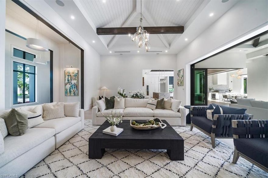 Experience unparalleled, luxury living in this recently completed new construction residence. Crafted by Falconer Jones, designed by award-winning Design West, and furnished by Arhaus, the expansive property with southern exposure is nestled on an oversized lot in the highly sought-after Moorings community. Spanning 5,000 square feet, all on ONE LEVEL, this home is the epitome of luxury Florida living, featuring lush landscaping and soaring ceilings reaching over 15 feet. Step into the grand entrance and be captivated by the seamless blend of indoor and outdoor spaces, perfect for entertaining with a Sonos sound system setting the ambiance. The chef's kitchen is a culinary masterpiece, equipped with Subzero and Wolf appliances, custom walnut cabinetry, and a striking waterfall island. Five spacious bedrooms, each with ensuite bathrooms, ensure comfort and sophistication, while the stunning great room provides an inviting space for relaxation. Outside, indulge in resort-style living with a 50-foot pool, outdoor kitchen and dining area, fire pit, and covered lounge with fireplace, ideal for gatherings and unwinding in style. This home is not just luxurious but practical too, with a Lutron lighting system, security cameras, automated roll-down screens, generator, and hurricane impact doors and windows. As a cherry on top, eligibility for Moorings Beach Club membership elevates the allure of this exceptional property. Don't miss your chance to own a piece of paradise in one of Naples' most prestigious neighborhoods.