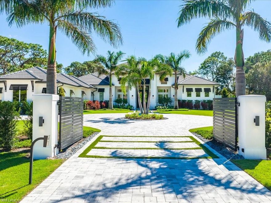 Captivating and stylish, this single-story Naples home set on 1.37 acres in the sought-after Pine Ridge Estates is one you're sure to admire. Manicured gardens and a gated circular driveway welcome you inside this 1-year-old residence where you'll discover high-end finishes and innovative design details throughout. French doors usher you into the expansive living room where vaulted ceilings are enhanced by exposed beams, large glass sliders frame your outdoor oasis, and a linear fireplace is flanked by sleek built-in shelving. Your seamlessly connected kitchen has an oversized multi-seater island, stainless steel appliances, gorgeous white cabinetry, and a pantry with a wine chiller. The luxurious proportions of the primary suite treat you to direct outside access, a walk-in closet with built-in organizers, and an opulent ensuite with a freestanding soaking tub and a two-person, multi-head shower. Enjoy ultimate outdoor entertaining on the covered south-facing patio with multiple sitting spaces, a built-in kitchen, a pristine pool with a spa, and a fireplace. As a bonus, you'll have a family room, an office, a laundry room, and an attached 3-car garage. Come for a tour today!