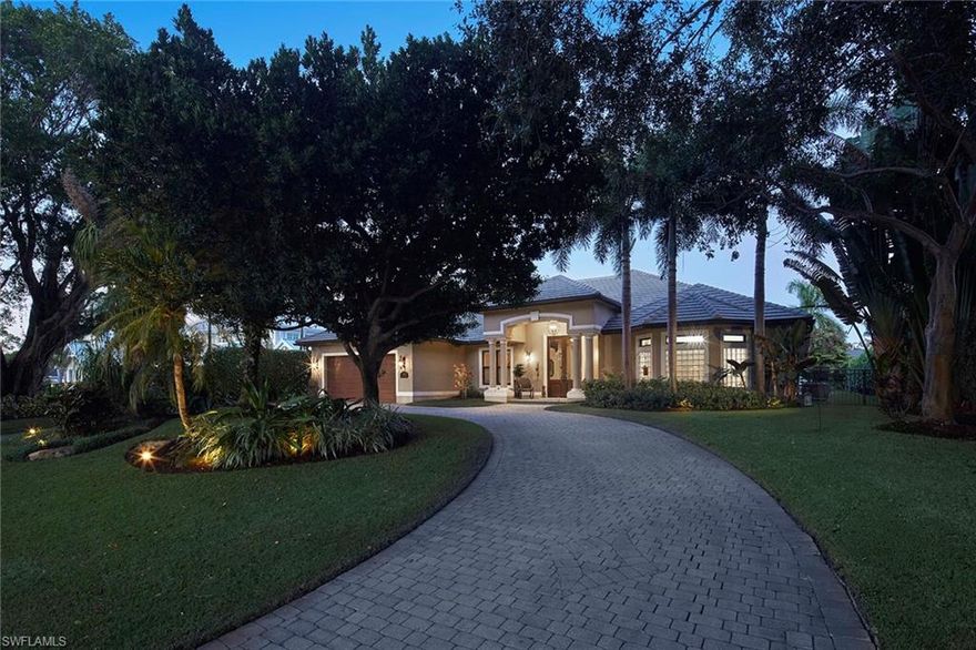 Set on one of the most coveted, highly elevated banyan-lined streets in The Moorings, this exceptional four-bedroom plus den residence offers refined coastal living designed for both grand entertaining and everyday comfort. Encompassing over 3,800 square feet, the open-concept great room floor plan is highlighted by soaring vaulted ceilings and an expansive dining area, all framed by tranquil views of the lush, private backyard.  Seamlessly extending the living space, the fourth bedroom has been thoughtfully reimagined as a sophisticated family lounge, complete with a wet bar and full bath. Dramatic 90-degree pocketing sliders open to a generous covered lanai, creating a flawless transition between refined indoor comfort and relaxed outdoor living. The secluded outdoor retreat is anchored by an oversized heated pool and elevated spa, complemented by a fully equipped outdoor kitchen, making it ideal for year-round enjoyment in Naples’ renowned mild winter climate.  Thoughtfully appointed, the home includes impact-rated windows and doors throughout, two dishwashers, a Generac whole-home generator, 750 gallon propane tank, an oversized attached two-car garage all on a beautifully landscaped .37-acre homesite. Perfectly positioned, this premier Moorings location is just a short stroll to popular restaurants and Publix, while residents enjoy exclusive access to the private Moorings Beach Park.  A rare opportunity to experience the ultimate in luxury, lifestyle, and location in one of Naples’ most desirable neighborhoods.