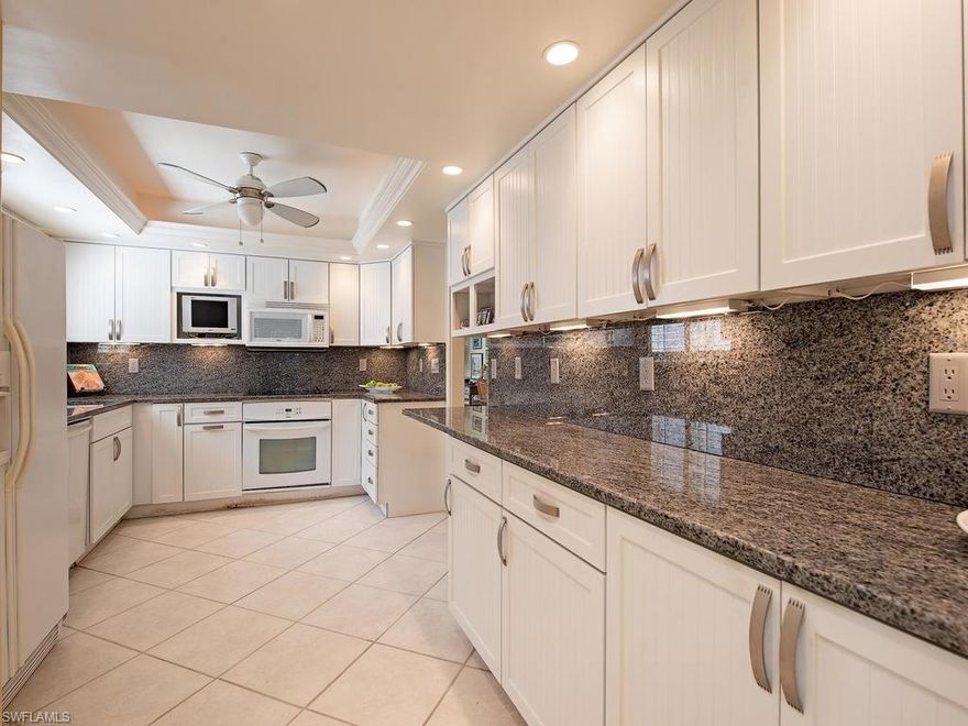 C.15036 - Welcome to Deja Blue at The Barclay… plantation shutters, beachy white & blue renovated kitchen and baths, and a custom built in office, are just a few of the lovely details of this sunny, renovated, end-unit right in the heart of Olde Naples. Located a mere 1.5 blocks to the Gulf and to the exclusive shopping & dining that make historic 5th Avenue S so special! Small complex of only 8 units with dedicated parking & storage under the building: so even this 1st floor unit sits above 5th Ave nestled in the trees. Elevator or stairs: take your pick! Pet friendly! Have your morning coffee or sunset cocktail on the screen lanai while enjoying the tree-filled, blue sky views. Generous master suite is filled with natural light and also opens on to the lanai with a sitting area, dressing area, walk in closet and linen storage. The separate, roomy guest suite can be closed off for total privacy for your guests with their own bath. Den can easily be used as an overflow sleeping space if needed. Storage galore! Ideal vacation home or rental property allowing 30 day rentals up to 12x a year if desired...Can be purchased furnished so you can literally move right in and start enjoying.