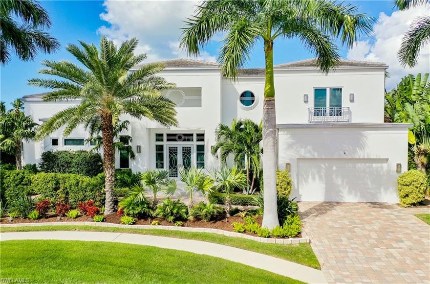 Marco Island Elegant Custom residence situated on KEY LOT HOMESITE with over 140 ft of WATERFRONT featuring a sleek white stucco exterior with stainless steel gutters. Upon entering through double hurricane impact doors, step into a coastal-inspired living space adorned with art deco touches. The master suite offers southwest views, his and hers closets, and a luxurious bathroom. First-floor ceilings reach to 13 feet, creating a spacious ambiance. The open floor plan seamlessly connects a generous kitchen, dining area, and family room, all capturing breathtaking water views. Upstairs, discover an office, a family room with a wet bar, and two en-suite bedrooms with access to an upper open patio. Outside, relish a screened lanai, pool/spa, paved patio, 2 boat lifts, and a large dock. The property, peacefully situated in a cul-de-sac near Tigertail Beach and Residents' Beach, is conveniently walkable or bikeable to both. This residence offers 4 bedrooms, 3 full baths, and 2 half baths, plus master bedroom suite on first level. Pavers line the driveway & walkways, lush tropical landscaping surrounds the home.
