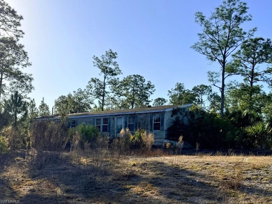 Discover the potential of this manufactured home situated on approximately 4.9 acres in the desirable Golden Gate Estates area. This property offers a peaceful rural setting with plenty of space for outdoor living, gardening, or future improvements. The home features a spacious layout and is surrounded by natural beauty, providing privacy and tranquility while still being within reasonable distance of shopping, dining, and everyday conveniences in Naples. A great opportunity for buyers seeking land, space, and the flexibility to make this property their own.