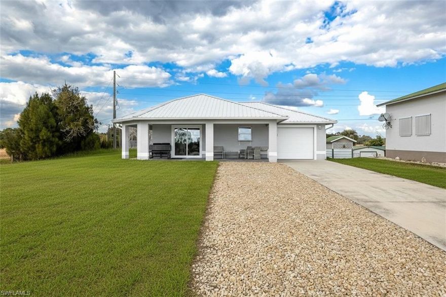 Enjoy beautiful Caloosahatchee River views from your living room and front porch, with convenient access to the nearby boat ramp—without the expense of riverfront ownership. Built in 2021, this home features oversized tile flooring, a metal roof, and upgraded impact windows and doors, all designed to maximize comfort, durability, and the spectacular water views. Located on a spacious corner .46+/- acre lot, in the Ortona community, just a short walk to the Ortona Locks, fishing dock and boat ramp.