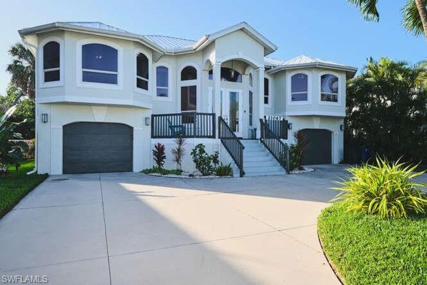 Stately elevated pool home with a screened enclosure, offering over 2,100 sq. ft. of thoughtfully designed living space. This spacious residence features 4 bedrooms plus a versatile den, and 2 full bathrooms. Situated on a desirable street lined with beautiful homes, this property is just a short stroll to a private beach access—perfect for enjoying gorgeous sunsets over the Gulf! Outstanding amenities include a newer heated pool with screened enclosure, multiple covered seating areas with TV, and a tiled feature wall with an electric fireplace. The outdoor living space offers direct access to a bar/entertainment area, making it ideal for hosting and year-round enjoyment. As you walk up the front porch area, there is a spectacular upgraded impact door, leading up the stairs to a huge great room/open floor plan with a living room on the right side and kitchen on the left with a large kitchen island with seating for 4 plus a dining area in the great room as well. The kitchen includes granite counters and all new black stainless steel appliances.  Another great feature is the split bedrooms with the primary suite on one side, two bedrooms along a hallway and a 4th bedroom off the living room. The primary suite includes a soaking jetted tub, walk-in shower with bench, dual sinks, and walk-in closets. The screened pool enclosure provides a private outdoor living space, ideal for relaxing or entertaining.  In addition, there is a nice bright den/office off the kitchen.  If you need storage, you will love the split garage with epoxy flooring throughout, room for 3 cars, plus tools, beach toys and more!  Live your Florida dream with this one of a kind elevated home that checks all the boxes! **Please NOTE: Home is in a weekly rental district, BUT the HOA requires only 1 rental per month with a minimum of 7 days.