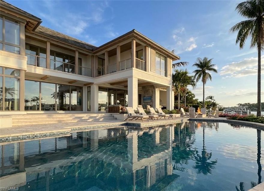 Experience a rare opportunity to own a spectacular new construction estate in Port Royal, timed for completion alongside the highly anticipated new Port Royal Club. Perfectly positioned at the end of a quiet cul-de-sac, this exceptional property captures sweeping, wide-water western views over private Buccaneer Bay — offering breathtaking sunsets and 179 feet of total water frontage. Built to today’s highest construction standards, this architectural masterpiece is being constructed by Toscana Homes, with plans thoughtfully designed by Stofft Cooney Architects and interiors curated by Carrie Brigham Design. Every element reflects superior craftsmanship, timeless design, and refined coastal luxury. The first floor is a true entertainer’s dream, where every room enjoys stunning water views and seamless indoor-outdoor living. Two spacious living rooms, an elegant dining room flanked by a walk-in wine cellar and full bar, and expansive glass openings create a setting designed for both grand entertaining and relaxed waterfront living. The gourmet kitchen is outfitted with Wolf and Sub-Zero appliances, custom Soho cabinetry, and a fully equipped walk-in prep kitchen to accommodate catered events or everyday ease. The primary suite is a private sanctuary, offering tranquil bay views and a spa-inspired bath featuring separate his-and-her bathrooms connected by an oversized walk-in shower, along with two generous walk-in closets. An additional guest suite and an expansive club room are also located on the main level — each overlooking the pool and sparkling bay beyond. Upstairs, four spacious en-suite guest bedrooms provide ultimate privacy and comfort. A second-level lounge offers a welcoming retreat for family and guests, complemented by a fully equipped fitness room and built-in sauna for a true resort-style experience. New construction opportunities with wide-water western exposure are exceedingly rare in Port Royal. Completion is anticipated for the end of 2026, with immediate Port Royal Club eligibility upon purchase — presenting a unique chance to secure both a legacy property and premier club access in one of the country's most prestigious waterfront communities.