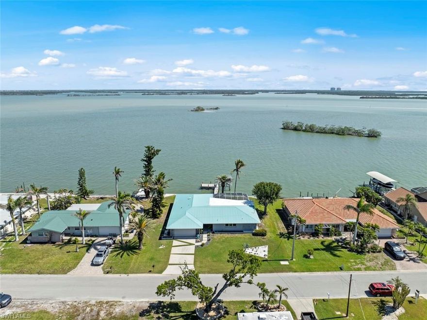 Luxury Bayfront Living in Fairview Isles Gulf Access & Deeded Beach Entry! Welcome to 7 Bayview Blvd, an exclusive bayfront estate offering 100 feet of DIRECT Estero Bay frontage in the sought-after Fairview Isles of Fort Myers Beach. This 4BR/3BA, 2,487 sq. ft. residence delivers panoramic Estero Bay views, refined modern design, and seamless indoor-outdoor living! Vaulted ceilings, an open-concept layout, two spacious living areas with Feature Wall, CUSTOM EPOXY FLOORS throughout, and expansive impact-rated sliders & windows frame stunning Bay vistas! The private primary suite features poolside access, a spa-style bath, and walk-in closet, while a split-bedroom design ensures guest privacy with 2 Bedrooms and adjoining bathroom. Deeded beach access just a short walk away. Boater’s dream with deep-water Gulf access, 13,000 lb. boat lift, and raised composite dock. Enjoy a resort-style HEATED pool & lanai with picture-window screen enclosure and upgraded cooling tile surround. Extensively upgraded for peace of mind: Solar Panels (2026), Flood Water Pro barrier system (2025), metal roof (2017), new ELEVATED seawall/dock/lift (2023), hurricane-impact windows & doors, Custom Impact Designer Double Front Door, updated electrical & plumbing, reinforced foundation, raised garage slab, and designer driveway. Gourmet kitchen with Cambria Quartz & Caesarstone waterfall counters, Samsung Bespoke appliance suite, wine refrigerator, and designer finishes throughout. Smart home features include security cameras, thermostat, keyless entry, Wi-Fi irrigation, and EV charging station. A rare opportunity to own a resilient, luxury waterfront home in one of Fort Myers Beach’s most desirable neighborhoods; complete with dolphin, manatee sightings, osprey and SUNRISE VIEWS! Make your private showing today!