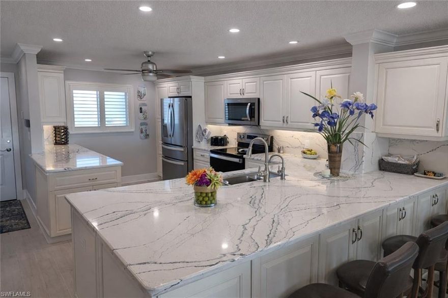 Beautifully remodeled, turnkey waterfront 2BR/2BA top-floor condo with breathtaking views in the sought-after Town & River boating community. High-end renovation featuring quartz countertops, custom cabinetry, stainless steel appliances, tile plank flooring, marble baths, built-in closets, IMPACT WINDOWS with electric shades, plantation shutters, and water purification system. Welcoming, all-ages community with resort-style amenities including heated pool, tennis & pickleball, shuffleboard, renovated clubhouse, fitness center, kayak racks, community boat slips with water & electric, car wash area, and elevators just outside the unit. Quick access to open water with no bridges. Includes covered carport and storage. Minutes to Downtown Fort Myers, Fort Myers Beach, Sanibel & Cape Coral.