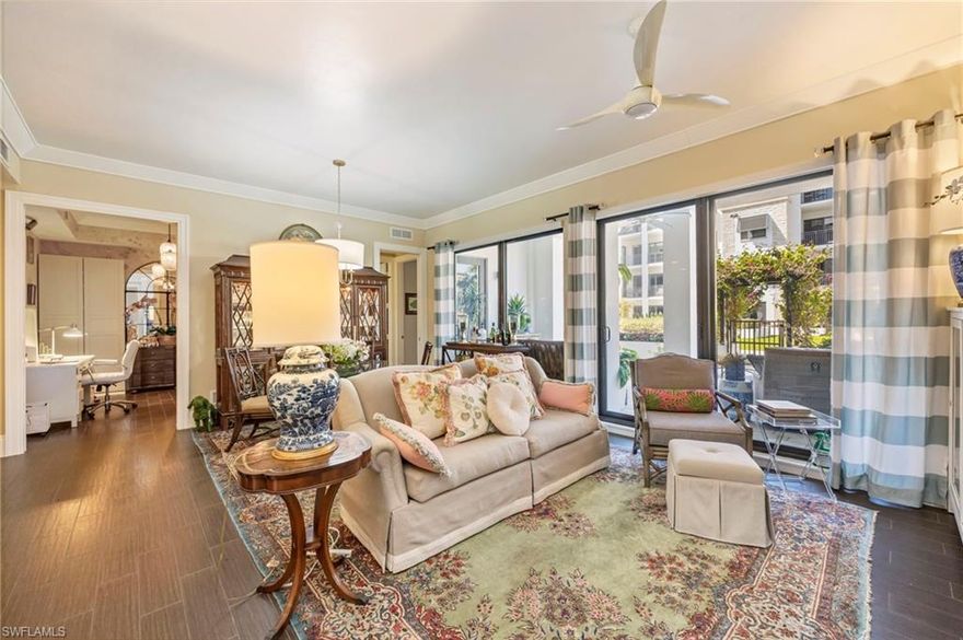 Motivated seller—an exceptional opportunity to own one of Naples Square’s most coveted courtyard-level residences. This exquisite, partially furnished condominium seamlessly blends luxury, convenience, and timeless British West Indies style, offering an elevated indoor-outdoor lifestyle in the heart of downtown Naples and in a pet-friendly community.
One of only 10 courtyard residences per building (out of 73), this home features an expansive 650 sq. ft. private lanai, perched more than 10 feet above street level to ensure privacy, tranquility, and peace of mind. Designed as a true extension of the living space, the lanai is ideal for both entertaining and relaxation, featuring two chaise lounges, multiple seating areas, and al fresco dining for six. Importantly, the residence remained high and dry through every storm season, further enhancing its exceptional value.
Inside, refined craftsmanship and thoughtful design are evident throughout. Highlights include Farrow & Ball English paint, a striking mother-of-pearl kitchen backsplash, quartzite countertops, and high-end KitchenAid appliances in the gourmet kitchen. The open-concept living and dining areas are enhanced by  built-in cabinetry and motorized shades, creating a sophisticated yet comfortable atmosphere. A spacious den—appointed with a Ballard Designs daybed and tall closets—offering versatility as a home office or guest retreat.
The primary suite is a serene sanctuary, featuring a generous walk-in closet plus an additional closet and a spa-inspired bath with dual vanities and an oversized walk-in shower. The guest ensuite bedroom, furnished with a stylish Ballard queen bed, is equally inviting, while elegant Thibaut wallpaper adds a refined touch to the guest bath and den.
This partially furnished residence (see  inventory list) also includes a well-appointed laundry room with a stackable washer and dryer, laundry sink, extra refrigerator/freezer, and a coffee/microwave bar. The home conveys with one reserved garage space and storage unit, along with access to additional open parking within the secure, gated garage.
Step through the garden-level flowering pergola and enjoy Naples Square’s resort-style amenities, including a pool, spa, fire pit, outdoor grilling area (grills are across the garden from this unit), and Club Room—all just moments from your door. Ideally located in downtown Naples’ Design District, this residence is within walking distance of world-class shopping, fine dining, and cultural attractions.
Whether as a full-time residence or a seasonal retreat, this exceptional home delivers a lifestyle of elegance, security, and effortless sophistication.