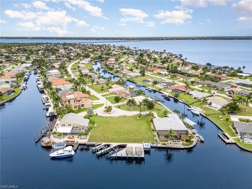 Like no other, and getting harder to find, this exceptional oversized triple lot is a rare Gold Coast gem in SE Cape Coral, just around the corner from the Caloosahatchee River. Set on a wide intersecting canal with an impressive 135 feet of waterfront, this is true direct Gulf access with no bridges, the kind of property serious boaters and luxury buyers search for and rarely find. With a brand-new seawall already in place, plus sunset views that light up the water every evening, the stage is set for a one-of-a-kind custom estate or a standout spec build.
The value is already here with major waterfront improvements completed: two brand-new docks, a 30,000 lb. boat lift, a 16,000 lb. lift, a double jet ski/kayak lift, and two tiki huts that turn the waterfront into your own private resort. Water and electric are in at the dock, and public utility assessments are in and fully paid, helping streamline your plans and protect your investment. Spanning approximately 0.354 acres, this rare triple lot offers the space, scale, and presence to create something truly spectacular. If you’ve been waiting for a direct Gulf access opportunity in the Gold Coast that checks every box, this is the one. Opportunities like this do not come along often.