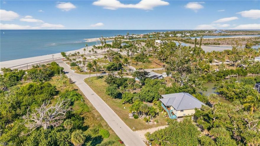 SO CLOSE TO THE BEACH THAT YOU CAN HEAR THE SURF, FEEL THE GULF BREEZE, AND BE AT THE BEACH IN MOMENTS. This Gulf access home combines the best of Sanibel: incredible proximity to the spectacular Blind Pass Beach and quick Gulf access from the backyard. Elevated with accordian shutters, a new metal roof (2024), and generator-ready, the house is built for resiliency and easy island life. A 30 amp RV outlet adds to the convenience of the property. With high ceilings in the great room leading to expansive front and back porches, the house offers a comfortable floor plan that beautifully combines indoor and outdoor living. Three spacious bedrooms with three full bathrooms provide plenty of space for family, friends and guests. The outdoor shower is a highlight, perfect for returning from the beach or from a day on the water. Mature tropical vegetation creates privacy and a gorgeous backdrop from windows and decks. An incredible opportunity to live at the beach with your boat in your backyard... this is island living!!!