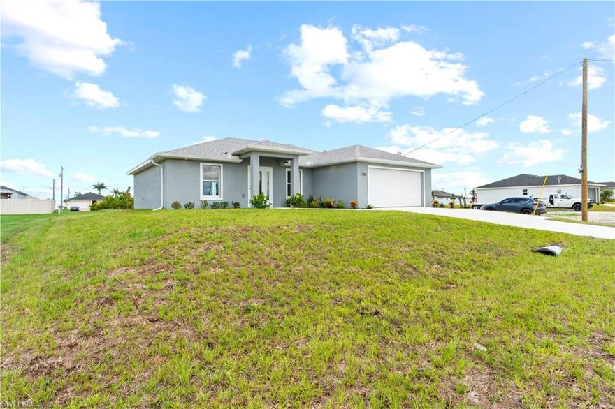 NO FLOOD ZONE. See this brand-new 1,500 square ft home in Cape Coral on CITY WATER WITH ASSESSMENTS PAID IN FULL. This beautiful home features 3 bedrooms and 2 bathrooms of comfortable living space. The home is situated with an oversized back yard.  Entering through the sidelit front entryway, you are welcomed by the open floor plan with a vaulted 12’ cathedral ceilings and upgraded floor tile throughout the home. The living room incorporates an energy efficient, impact resistant sliding door and windows for an abundance of natural light. The spacious kitchen is open to the main living areas. It features brand-new energy-efficient stainless-steel appliances, quartz countertops, a pantry, a beautiful waterfall center island with plenty of storage and bar-top seating. The cabinets feature Shaker soft close doors and drawers through out with a dining area overlooking the oversized covered lanai and backyard. The master suite offers upgraded tile throughout with a walk-in closet and bathroom with dual sinks and a large shower. The guest bedrooms and bathroom also include upgraded floor tile with ample space for children or welcomed guests. Lighted ceiling fans adorn all of the bedrooms and living room. The home is upgraded for HDMI and USB in each room. Modern finishes throughout make this home move-in ready. Located in a great neighborhood with easy access to shopping, dining, and more. This home offers comfort, convenience and style at an affordable price with all of the many upgrades.