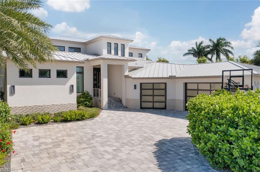 Waterfront Contemporary Smart Home with all the features you have been looking for. Come experience the best of Florida living with an Amazing outdoor space which includes an infinity pool with spa with glass wall, summer kitchen, multiple balconies to take in the breathtaking water views. Dock and 10,000 LB boat lift with a location minutes to open waters.  Bright and open layout with grand Family Room with soaring ceilings, stonewall with fireplace and ample natural light.  Sleek and upgraded kitchen has Quartz counters, island with breakfast bar, upgraded appliances with dual ovens and an espresso machine. Eating area in kitchen with built in bench and more picturesque water views. Master Suite is spacious with tray ceilings and oversized bath features two sinks, beautiful vanity area, tub and walk in shower. Loft at the top of the stairs great for a game area - complete with a mini kitchen and offers a bird's eye view of the family room. Features throughout the house include hurricane impact windows, ICF rated home, tile and wood floors, surround sound and aluminum roof. Elegant modern living and premiere boat life to some of the worlds best fishing await you! Move in ready!