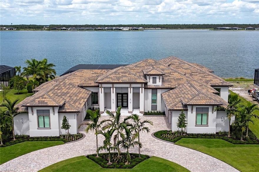 Stunning former model home now available and being sold furnished! Professionally furnished and decorated by Cardamon Interiors. Located on a prime lake view home site at the tip of the Peninsula at WildBlue. 140 feet of lake front!  This owner added over $250,000 in upgrades including whole home generator, boat dock with lift, updated lawn/landscaping, automated hurricane screens on the lanai, and electric blinds in all the bedrooms. This open floor plan features 4 Bedrooms, Office plus an Ensuite Flex Room, 5 Full Bathrooms and 1 Powder Bath plus 4 car garage.  All the elegance you’d expect in a new luxury home - Sub Zero/Wolf appliances, Anderson impact windows, Control 4 Home Automation, walk-in glass wine cellar, and much more.  Outside Living encompasses over 1500 Sq ft of covered lanai with kitchen, fireplace, and lots of seating along with a custom pool/spa, firepit and incredible lake views. The new clubhouse with resort pool and beach just recently opened and ready for you to enjoy all the incredible amenities at WildBlue!