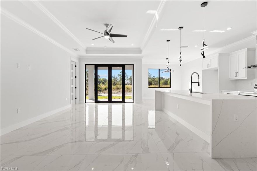 Experience modern Florida living in this beautifully designed 3-bedroom + den, 2-bath estate offering almost 1,700 sq. ft. of living area and 2,398 sq. ft. total. Built on a solid monolithic foundation with retaining walls on both sides, the home features an extended driveway that seamlessly continues to the back of the property—perfect for additional parking, storage, or future outdoor enhancements.

Inside, the home showcases an elevated level of craftsmanship and style. Enjoy porcelain plank tile flooring throughout, complemented by large-format designer tile in both bathrooms. The kitchen is a standout, featuring solid wood cabinetry, stainless steel appliance package, and a built-in mini fridge for added convenience. Upgraded modern plumbing and lighting fixtures give every room a clean, contemporary feel.

The smart layout includes a versatile den, ideal for a home office or flex space, alongside three spacious bedrooms and two well-appointed baths. Thoughtful design, premium finishes, and functional features come together to create a property that is move-in ready and built to impress.