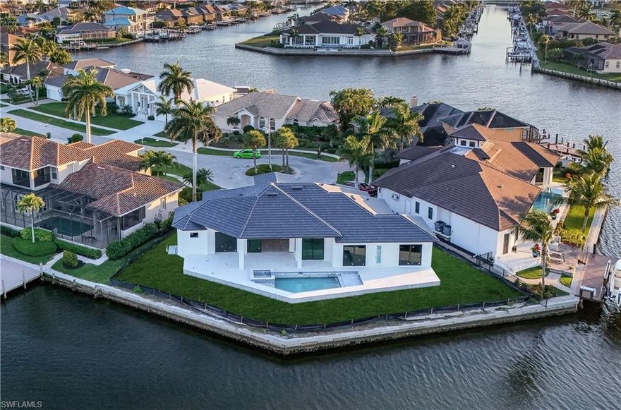 This custom designer coastal home on a tip lot with 160'ft deep water frontage, wide waterway views and easy indirect Gulf boating access, is under construction by builder, NOVA Homes of South Florida. Welcome to the epitome of waterfront luxury living, on a private cul-de- sac in an upscale Marco Island residential neighborhood close to Island Country Club. With 3 bedrooms | 3.5 baths | 3,789 square feet under roof | 5,175 square feet total; this single level home is designed to define the essence of coastal elegance. The residence spans 160 feet of waterfront along the serene Seminole Waterway, featuring unparalleled 2-way views of converging waterways and a long water view of the bay and golf course. As you step through the grand entry foyer, you're greeted by a sprawling open-concept great room, dining area, and kitchen, seamlessly integrating indoor and outdoor living. Adorned with top-of-the-line finishes and fixtures, the Chef's kitchen boasts a spacious island breakfast bar, gas range and double oven, while the walk-in pantry ensures ample storage. Dine overlooking the waterways. Retreat to the sumptuous master suite on one side of the home, complete with a huge walk-in closet and adjacent study. Indulge in the spa-like primary bathroom, featuring a walk-in shower, water closet and freestanding tub for relaxation and luxury. On the other side of the home are 2 ensuite bedrooms, while all bedrooms access the lanai and are indulged with outstanding water views. Entertain with ease on the sprawling covered lanai, overlooking the pool with a sun shelf and spa, complemented by a convenient pool bath and outdoor kitchen with built-in grill along the waterfront. Additional features include a generously sized laundry room, fenced yard, electric storm shutters, and a whole house generator, ensuring peace of mind and comfort. This brand new residence offers the perfect balance of spaciousness and waterfront living at its finest, with panoramic water views, serving as the backdrop to your Florida coastal oasis.