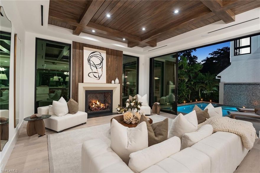 Just minutes from the world class shopping and dining on 3rd Street South & Fifth Avenue South, this brand new, never lived in residence embodies refined living in the heart of the highly sought after Olde Naples neighborhood. Blending natural textures with contemporary elegance, the home offers five bedrooms + study, light-filled interiors, and a seamless connection to the outdoors. Walls of sliders open the flexible outdoor living area & kitchen to the pool, creating a harmonious flow between inside and out. Unwind as the sun sets, a glass in hand, embraced by the privacy of your own retreat. At the heart of the gourmet kitchen, a dramatic Calacatta Lasa quartzite island anchors the space, complemented by custom SOHO cabinetry and Wolf appliances, while a striking counter to ceiling window bathes the room in natural light. Multiple stone and wood selections throughout create a warm yet modern atmosphere, while the open design makes everyday living and special occasions effortless. The main level wet bar with chilled wine storage is detailed with a romantic blue Quartzite setting the scene for evenings of gathering, while the upstairs morning bar invites guests to begin each day with ease and elegance. Additional details of note include a built-in generator, motorized screens, Control 4 automation, three car garage and quality of construction to last a lifetime. This Olde Naples gem is the perfect balance of luxury, comfort, and location—steps from the Gulf and curated for the ultimate Naples lifestyle.