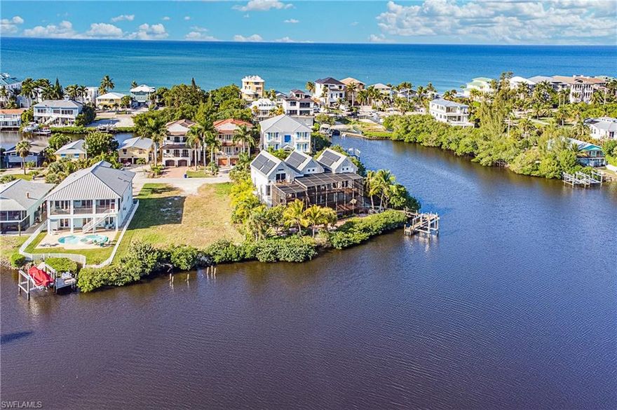 This stunning, well-appointed waterfront property offers DIRECT GULF ACCESS and is just one block from Bonita's white sandy beaches. Enjoy Southwest Florida's active lifestyle with a bike ride to Doc's Beach House, or simply take in the peaceful panoramic views of FishTrap Bay from every room in the home.
This home features 4 bedrooms plus den, 3 full baths and was thoughtfully designed by well-known local architect Larry Warner. His vision, brought to life in this home, includes bonus loft that give this home a timeless feel with a total of 3260 square feet of living space with soaring vaulted ceilings throughout. You'll appreciate the energy savings, as this home is powered completely by solar and has hurricane impact sliders.
The outdoor area creates a private, tropical oasis and is a perfect spot for entertaining with a 2 level deck and newly renovated saltwater pool with a lap swimming area. The raised spa is an eye-catcher, complete with an inviting water slide! This oversized lot extends out and offers a beautiful dock and 10,000 lb boat slip.  There are additional entertaining areas throughout the property. The opportunities are endless with this unique home!