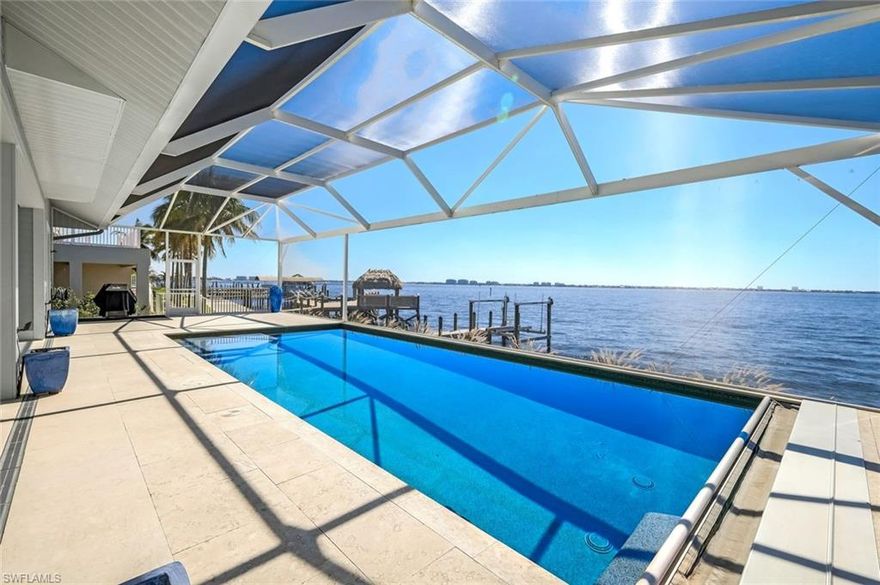 Simply the best! Southern Exposure Riverfront Home in the prestigious Yacht Club area of Cape Coral. This 2-story boater's dream home offers unparalleled luxury with sensational views from the expansive pool deck. This 4-bedroom, 4-bathroom custom designed and built home has been designed for ultimate relaxation. The extremely large pool deck features an electric heated pool with sun shelf and state-of-the-art electric powered retractable pool cover. The pool deck was designed to provide a huge under-truss shaded area for multiple spots for dining and entertaining seating options. There is also a half bath on the pool deck for added convenience. This home offers 4 spacious bedrooms and 4 bathrooms, all ensuite. The home features 2 Master Suites. The ground floor suite includes disappearing sliders leading to the pool deck so blend inside and outside living. The second floor Master suite also has a private balcony overlooking the pool deck and with panoramic river views. The gourmet Kitchen was remodeled in 2023 with Quartz countertops, an island with built-in induction cooktop, stove and microwave. The walk-in Pantry is a dream! This home is built to a very high standard with hurricane-impact windows and doors, tile floors and remote-controlled window coverings. Being sold furnished. Do not miss the opportunity to own this exceptional custom built riverfront home in one of the best streets in Cape Coral.