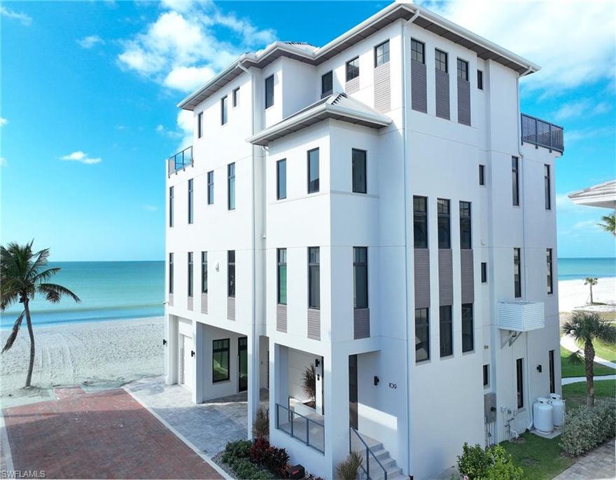 This 4 story Barefoot Beach Front Home offers Gulf views and sunsets that will take your breath away from every floor and every room.  The timeless coastal contemporary design, detailed care and maintenance of this home makes it feel as if it was just completed.  The 5,782 AC SQ FT provides for a spacious open floor plan, Grand living areas, generous room sizes, 5 bedrooms + den, 7-baths including a second cloud living area.  The 9,472 total living SQ FT provides for amazing outdoor living areas, summer kitchen, open decks, pergola deck with gas fire bowl all right on the beach plus a car collector size garage.  The value of this beachfront site cannot be understated as there will never be a home built close to this home on the beachfront where it is 218 feet to the next beachfront home to its north and 30 feet to the south, whereas the normal side setbacks between homes in Collier County and Naples are just 7.5 feet. Add to that there are no public beach access points within the Barefoot Beach community you have one of the most private beach settings imaginable. Windover Development, Kukk Architecture, Potter Homes and Freesyle Interiors, all first class, brought their best to create this amazing home.  Offered turnkey furnished so you can move right in and enjoy this season. The main level chef’s kitchen includes Wolf/Sub-Zero appliances, quartzite countertops, custom wood cabinets & classic white oak hardwood floors and opens to the dining room, great room & outside lanai via 10’ electric sliding glass doors plus guest bedroom 2 w/ensuite bath & a half bath. The master bedroom, bath and private lanai are spread across the whole width of the home where you feel like you are floating on the Gulf from your bed or the freestanding tub. The office/den has private access from the master bedroom and bedroom 3 w/ensuite bath & laundry complete the 3rd level. The top floor offers a large cloud living room with detailed vaulted ceilings and guest bedrooms 4 & 5 both w/ensuite baths plus an open deck with fire bowl.  Amenities inc Crestron home automation, private elevator, detailed millwork including ceilings, designer plumbing & light fixtures,  concrete construction, Andersen impact windows, motorized screens, storm shutters & sliders, plus aluminum snap-clad metal roof system. Barefoot Beach, Collier County’s premier gated beach to bay community, amenities include 24 hour guards and patrols, Clubhouse with fitness, tennis, pickleball full time on site Manager, beach garden pool and more. Option to join the Club at Barefoot Beach (located in the community) which offers casual & fine dining restaurants, pool & beachside food, drinks, chair service, indoor & outdoor bars, ice cream & coffee shop, tennis courts with pro & a full events calendar. (waitlist with usage during wait period). Minutes to Mercato, Coconut Point Mall, Promenade & Waterside, the airports and golfing.  Boat docks are available for lease or purchase right across the street.