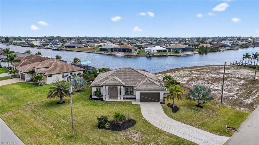 Where the sun melts into the horizon and shimmering canals stretch endlessly toward the Gulf, a rare piece of Southwest Florida paradise awaits. Positioned on an expansive .38-acre corner estate, this modern waterfront residence blends architectural elegance with the effortless beauty of coastal living. Set along 200+ feet of intersecting canals, the property offers sweeping, cinematic water views from dawn to dusk. Boaters will appreciate the direct Gulf access, 10,000 lb. lift, and L-shaped dock, creating a seamless gateway to open water adventures. A spacious waterside patio invites sunset gatherings, morning coffee rituals, and evenings by the fire as the sky glows in shades of gold and coral. Inside, natural light pours through the open layout, illuminating a space crafted with intention and sophistication. The gourmet kitchen features, Granite countertops throughout, Luxury cabinetry, stainless steel appliances, a grand center island perfect for entertaining, a formal dining room, three serene bedrooms, and a generous den/office offer both comfort and versatility. The primary suite is a private retreat, complete with a spa-inspired ensuite featuring a double vanity and oversized walk-in shower.  newly completed saltwater pool (12’ x 32’ with sundeck, 6.5’ deep) glistens beneath the screened enclosure, offering multiple lighting options to set the mood for evening swims or daytime relaxation. The lanai becomes an extension of the living space—airy, inviting, and perfectly positioned to capture the southern exposure and unforgettable sunsets. Just minutes from Crystal Lake Park and Charlotte Harbor Preserve, the home offers immediate access to boating, fishing, kayaking, sailing, and the untouched beauty of Florida’s Gulf Coast. Here, every day feels like a vacation—where nature, luxury, and tranquility converge.