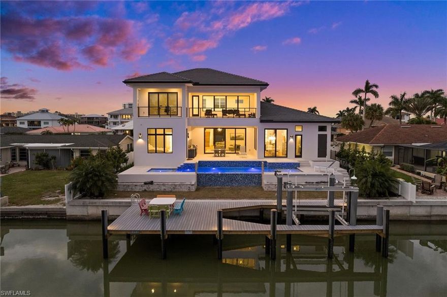 Presenting a brand new, two-story oasis featuring 3 bedrooms plus an office, recently completed and ready for occupancy. Boasting an enviable location, this residence offers access to the Gulf of Mexico via the canal, complete with a boat dock, lift, and decking—perfect for boat enthusiasts.

This home is designed for luxury living with an elevator, a spacious 3-car garage, and a versatile full-size office that could easily serve as a 4th bedroom. Enjoy the cozy ambiance created by the electric fireplace and the convenience of a lap pool with a spa. Additional highlights include a loft area, expansive second-floor balconies offering breathtaking water views, and a kitchen adorned with a stunning countertop with blue hues that match the fireplace wall.

This bright and airy sanctuary provides a unique and inviting atmosphere that must be experienced firsthand. Schedule a viewing to truly appreciate the spaciousness and abundant natural light that define this exceptional home.