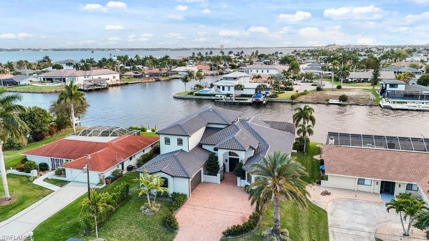 Reintroduced to the market with significant enhancements, this extraordinary waterfront residence is a true statement of luxury, elegance, and Southwest Florida lifestyle. Perfectly positioned on a direct access canal with approximately one minute to open water, this exceptional property offers a rare blend of boating convenience and breathtaking beauty, with sweeping river and open water views that create a spectacular backdrop from the moment you step inside. Recent improvements including a new roof, new dock, and new lift further elevate the appeal, offering both peace of mind and immediate enjoyment for the discerning waterfront buyer. Designed to capture the best of its remarkable setting, the home features a second story balcony overlooking the water, while the sought-after southern exposure fills the residence with natural light throughout the day and provides the rare pleasure of enjoying both sunrise and sunset from the lanai. Whether hosting elegant gatherings, savoring quiet mornings on the water, or departing from your private dock for a day on the Gulf, this residence delivers the kind of refined coastal living few properties can offer. This is more than a home, it is a waterfront masterpiece in one of Cape Coral’s most desirable boating locations.